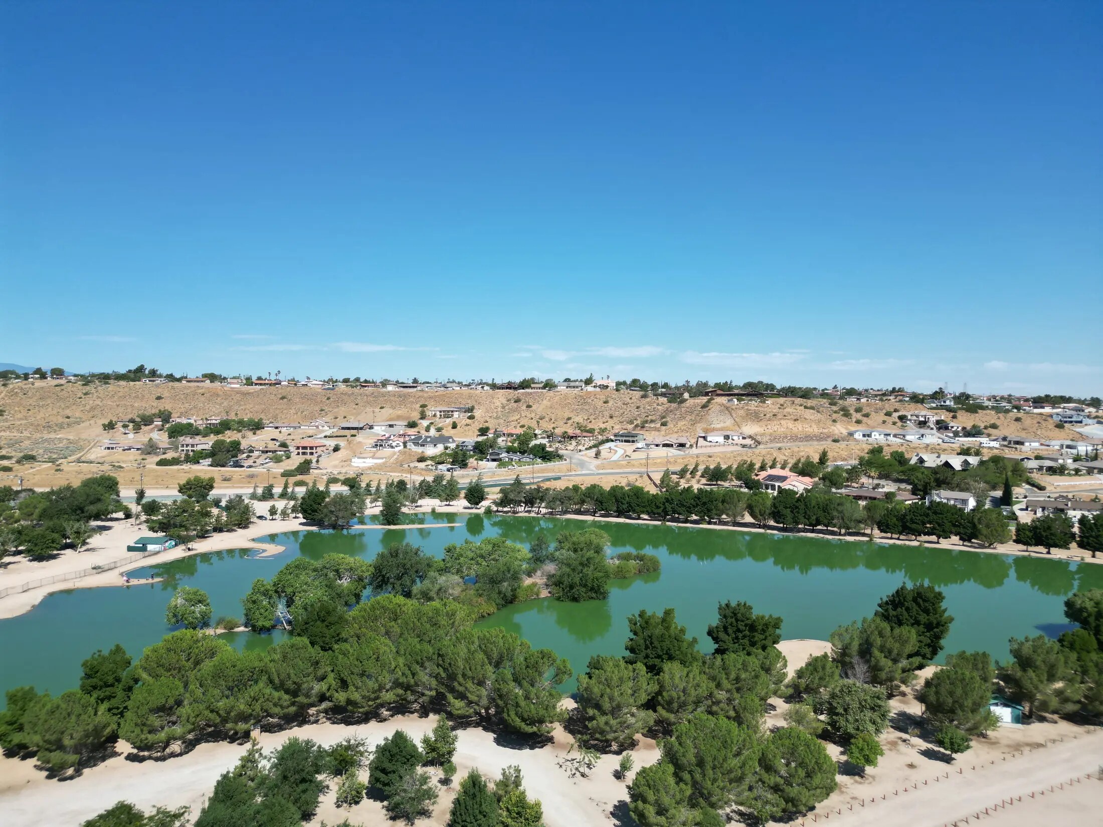Wide High Desert aerial view with clear land, road, and property context
